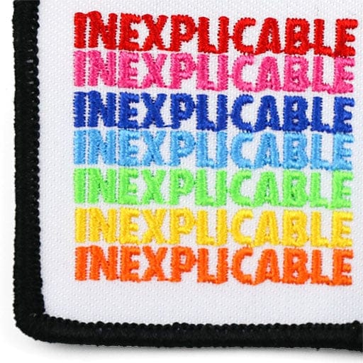 White embroidered patch with repeated instances of the word inexplicable in a variety of colors