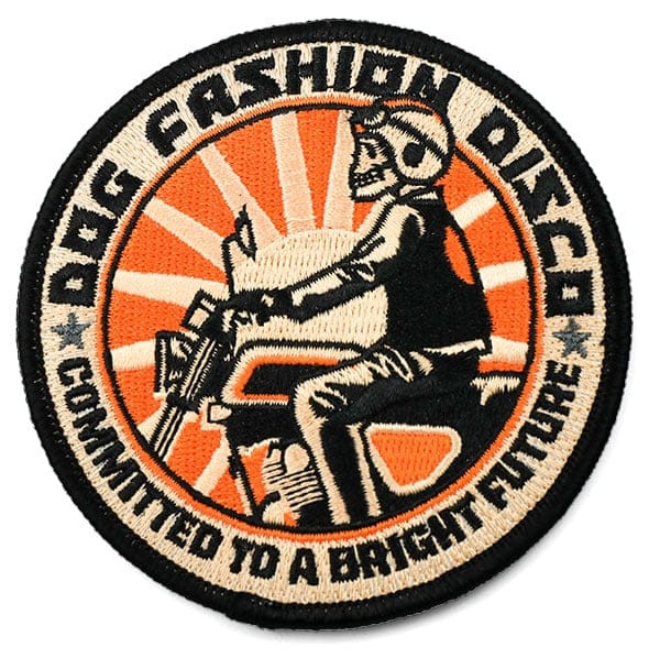 Black, orange, and tan circular embroidered patch with skeleton riding motorcycle: Dog Fashion Show, Committed to a brighter future