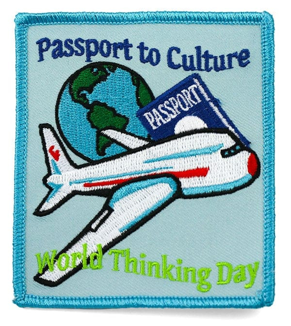 Blue, green, white, and red rectangular embroidered patch with airplane and world graphic: Passport to culture, World thinking day